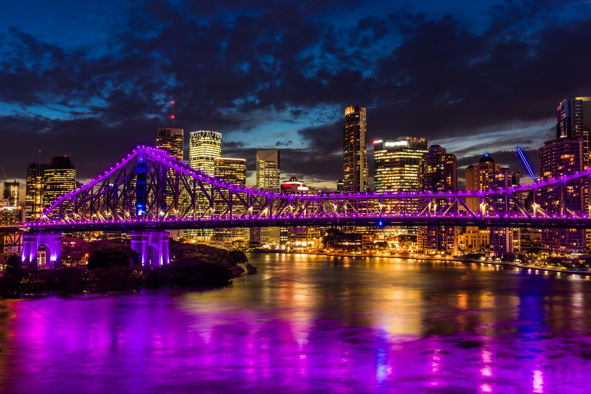 Vibrant night time panorama of Brisbane city with Story Bridge